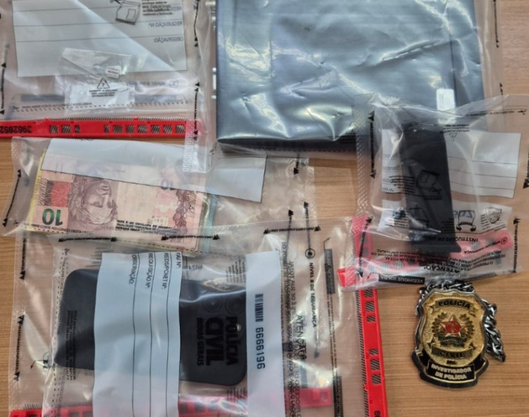 Diversos itens em embalagens plásticas, incluindo um pedaço de tecido cinza, uma cédula de 70 reais e objetos identificados como pertencentes à polícia civil.