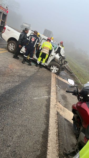 Equipe de resgate atendendo um acidente de carro em uma estrada nevoenta.