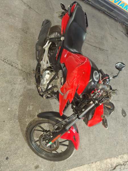 moto esportiva vermelha com detalhes pretos estacionada em um piso de cimento