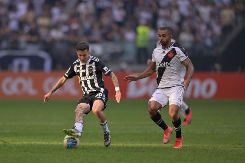 Two soccer players compete for the ball on the field during a match.