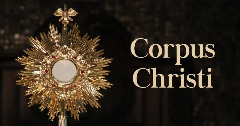 Monstrância dourada com detalhes em vermelho e símbolo da pomba, com a inscrição 'Corpus Christi' ao lado.