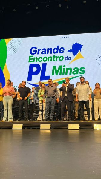 Evento político intitulado 'Grande Encontro do PL Minas' com várias pessoas no palco diante de um banner colorido.