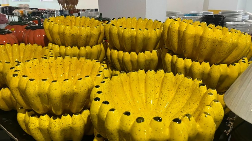 Stacked ceramic bowls in a bright yellow color with a decorative ribbed design and speckled finish.