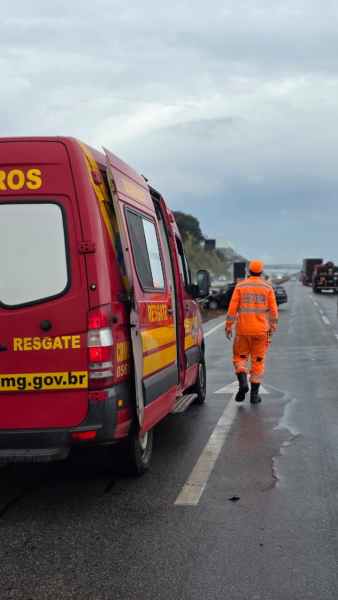 Um caminhão de resgate dos bombeiros em uma rodovia com um bombeiro vestido de laranja caminhando em direção ao horizonte.