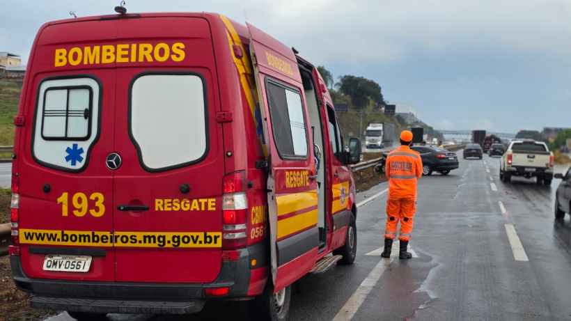 Veículo de resgate dos bombeiros estacionado em rodovia, com profissionais em traje de emergência observando o tráfego.