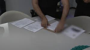 Uma pessoa organizando documentos sobre uma mesa.