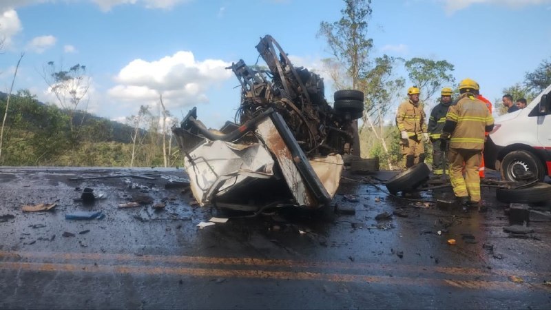 Acidente de trânsito com um veículo danificado e destroçado em uma estrada, com bombeiros e equipe de resgate no local.