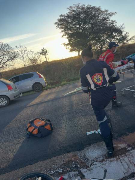 Equipe de socorro atendendo um acidente de trânsito em uma estrada, com veículo estacionado ao fundo e equipamentos de emergência.