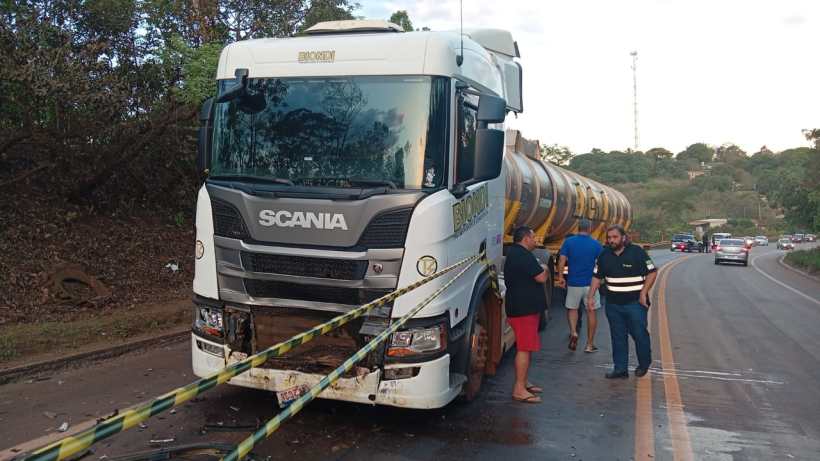 Caminhão Scania parado na estrada com um grupo de pessoas ao redor, discutindo a situação.