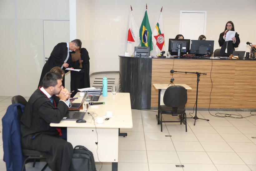 Audiência judicial com advogados na bancada, apresentando documentos e usando computadores. No fundo, bandeiras de diversos estados.