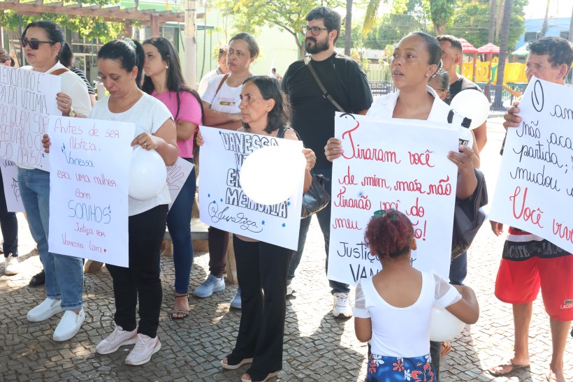 Manifestação em homenagem a Vanessa, com pessoas segurando cartazes e balões brancos, pedindo justiça e lembrando dela.