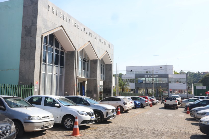 Fachada da Prefeitura Municipal de Niterói, com carros estacionados em primeiro plano e o Fórum ao fundo.