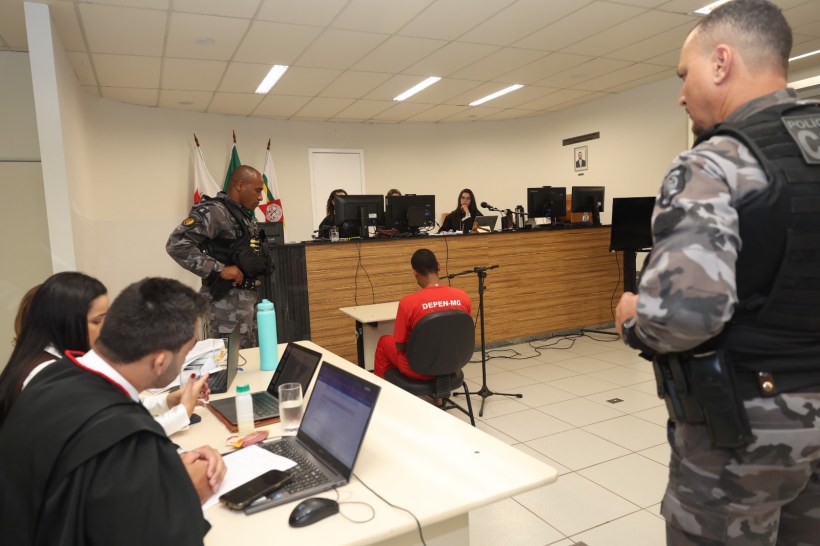 Audiência judicial com policiais e profissionais do Direito em um tribunal.