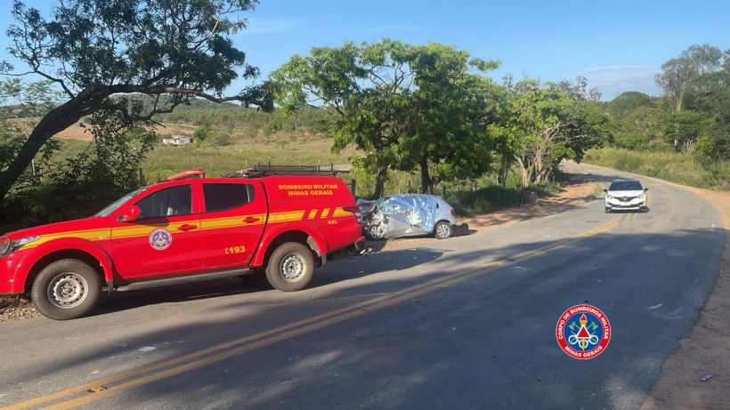 Veículo dos Bombeiros Militares de Minas Gerais na estrada ao lado de um carro acidentado.