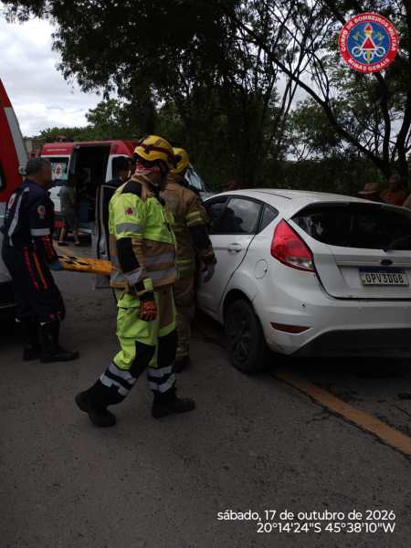 Equipes de resgate atendendo um acidente de carro com um veículo branco e pessoal de emergência trabalhando na cena.