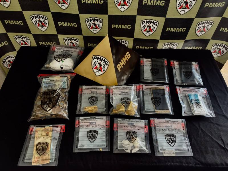 Monte de evidências coletadas, incluindo pacotes plásticos com materiais diversos, uma pirâmide dourada com a inscrição PMMG e uma placa de identificação, sobre fundo preto com logotipos da PMMG.